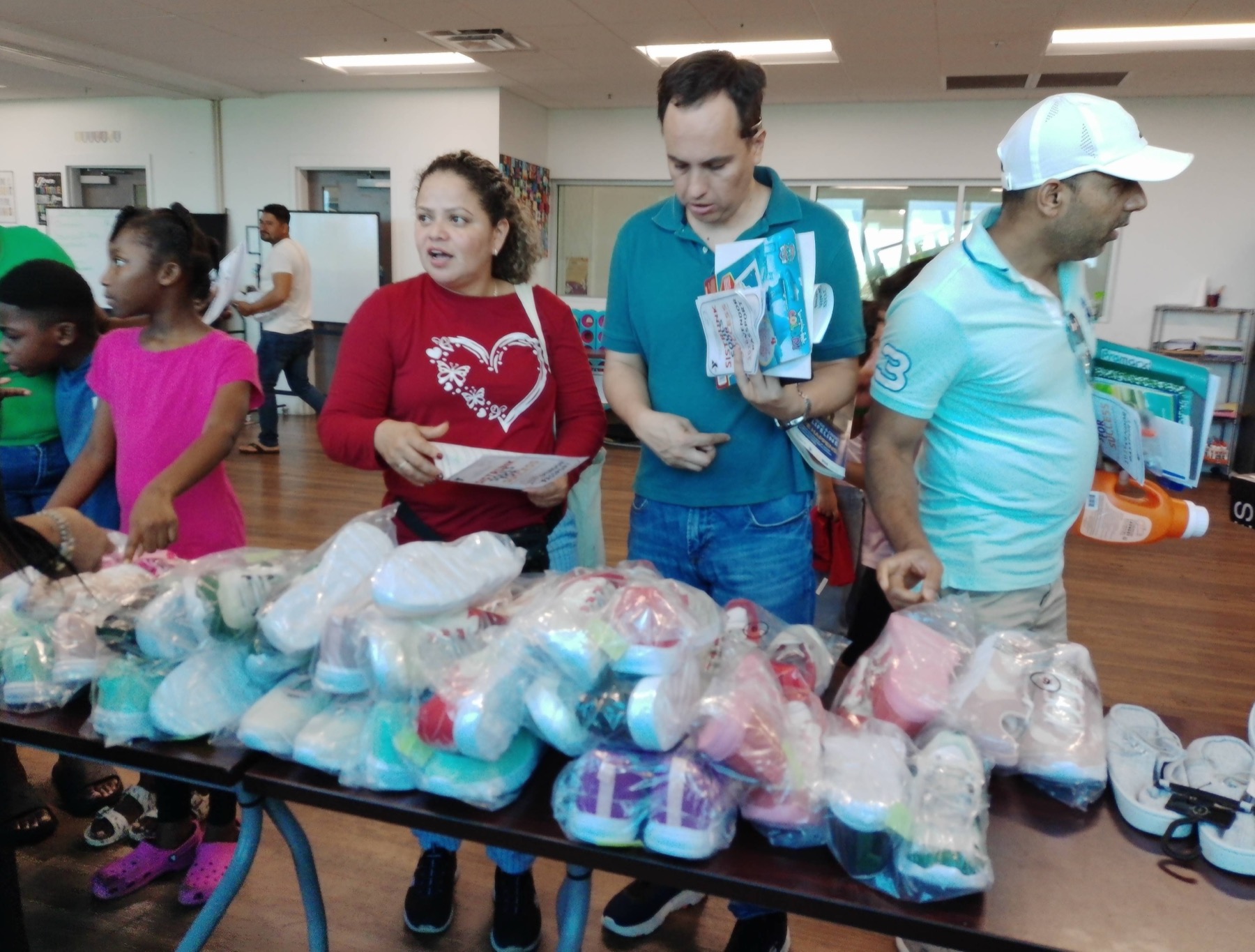 Families and volunteers sorting children’s shoes at a back-to-school event